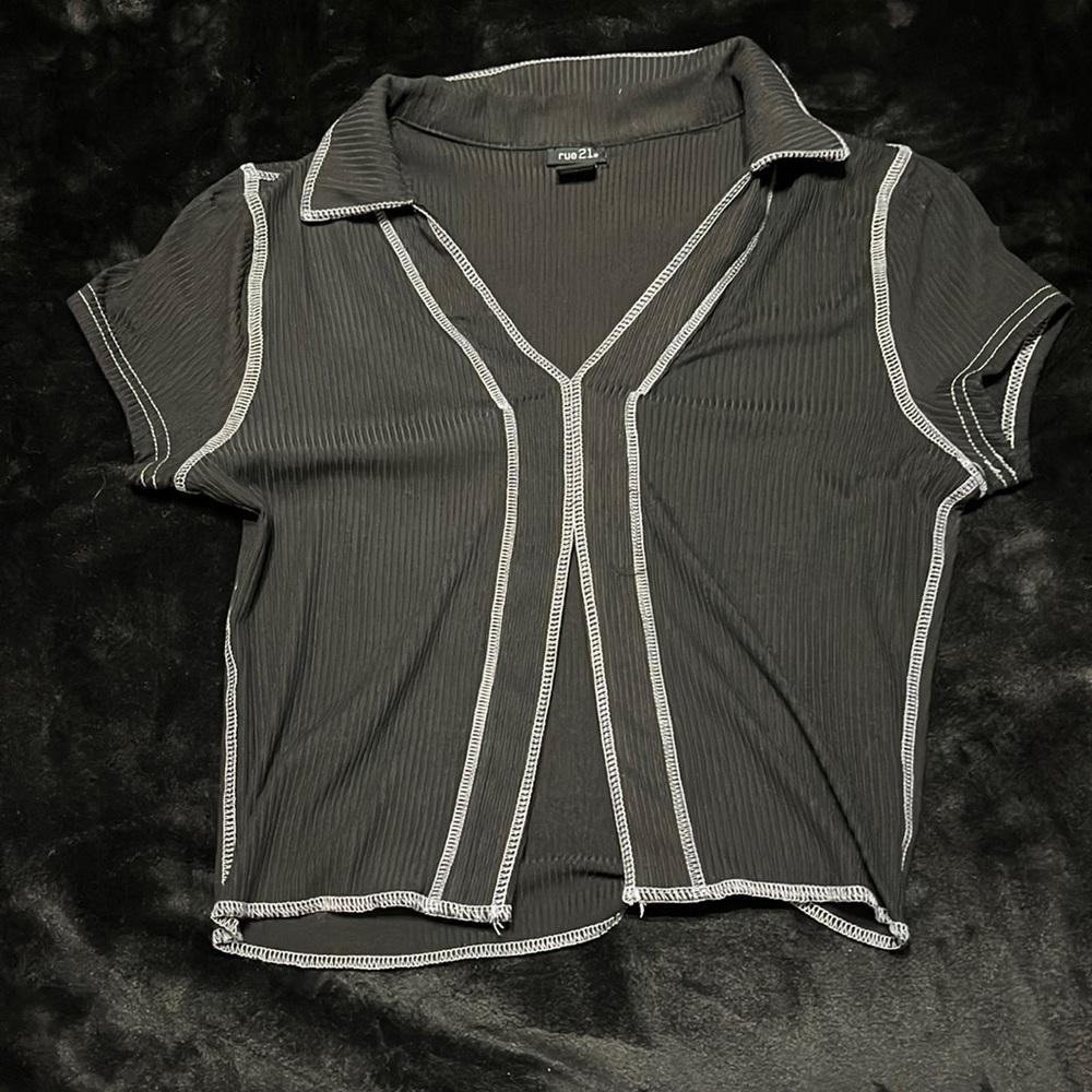 Black crop top has slit down the middle.